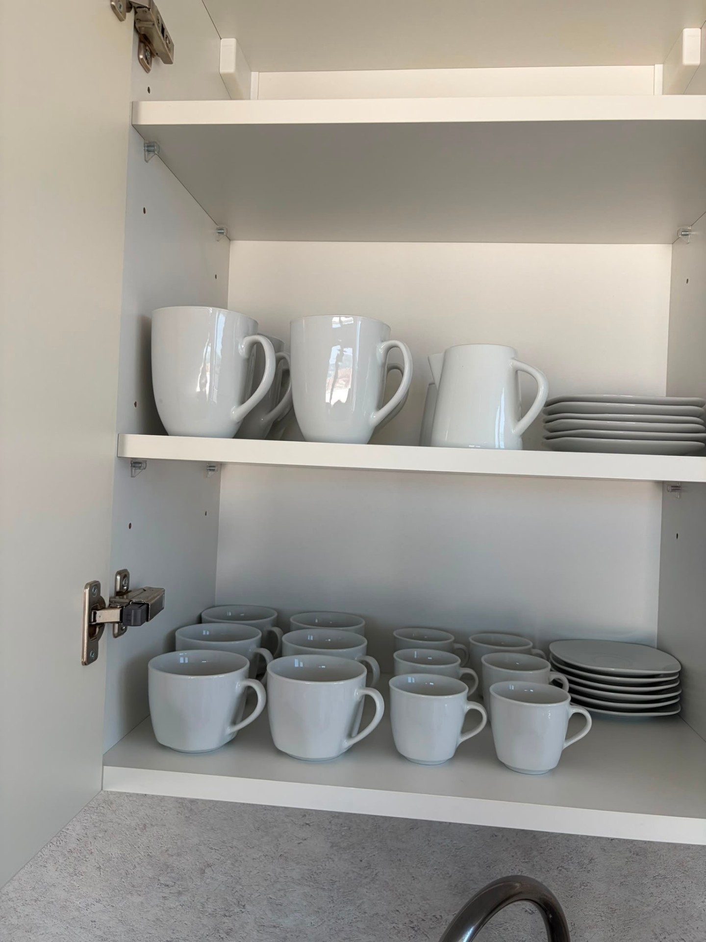 Mugs, cups and jug in the cupboard