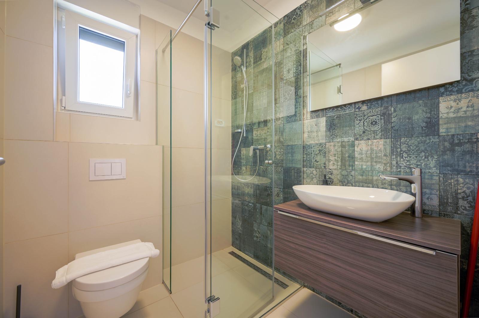 Shower with blue and green patterned tiles